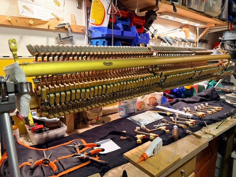 Große Messing-Instrumententeile, die auf einer Werkbank mit Werkzeugen und Teilen zerlegt wurden